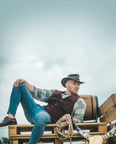 Cowboy granjero en el campo vistiendo sombrero vaquero occidental. Modelo masculino americano en el campo en la granja. Los hombres de moda retro, moda vintage, modelo masculino brutal. —  Fotos de Stock