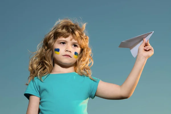 ウクライナの旗の上に空を閉じます。ウクライナ上空に飛行禁止区域はない。子供の頬にウクライナの旗。ウクライナ人の子供を守る。戦争も戦争もロシアの侵略も。ウクライナ人の愛国者. — ストック写真