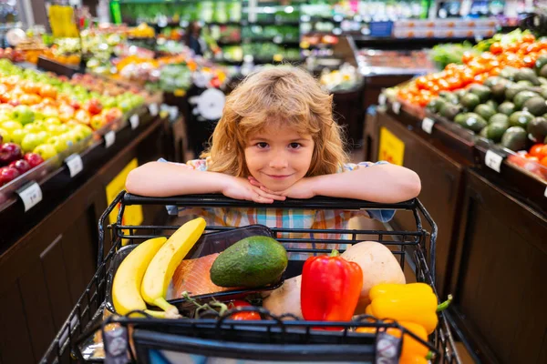 Shopping per bambini al supermercato. Cibo sano per bambini. Bambino nel supermercato compra verdure. — Foto Stock