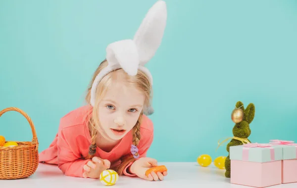 Девочка с пасхальными яйцами. Удивлённая девушка носит кроличьи уши на весенних праздниках. Праздничное оформление, символ, традиция, празднование, подготовка. — стоковое фото