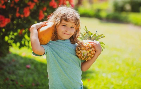 Bahçesinde ananas ve hindistan cevizi olan bir çocuk. Çocukların yaz vitamini. Tropik meyveler. — Stok fotoğraf