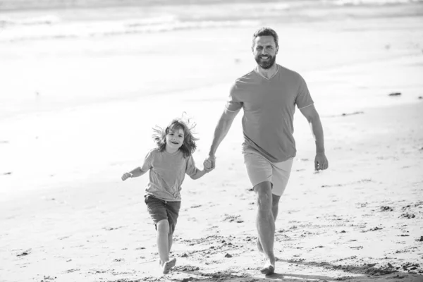Familienreisen, Urlaub, Vatertagskonzept. Vater und Sohn rennen auf See. — Stockfoto