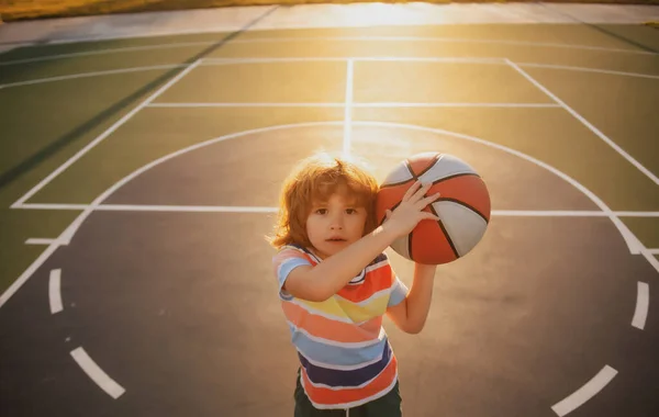 Barnpojken förbereder sig för basketskytte. Bästa sporten för barn. Aktiva barn livsstil. — Stockfoto