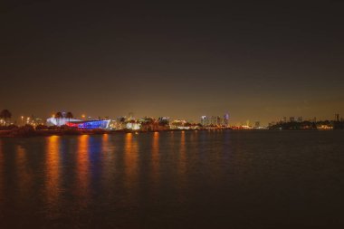 Miami, Florida şehir merkezi Biscayne Körfezi 'nde. Günbatımında şehir gökdelenleri ile Panorama ve yansıma ile deniz üzerinde köprü.