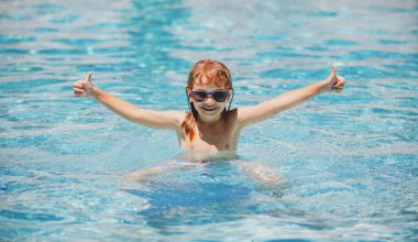 Çocuklar tropikal tatil köylerinde oynarlar. Aile plaj tatili. Yaz yüzme havuzunda bir çocuk. Çocuklar yüzmeyi öğrenir..