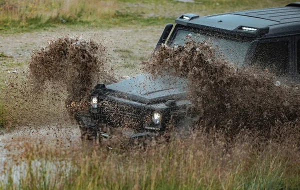 Terénní vozidlo uvízlo na neproniknutelné silnici po dešti na venkově. Cestovní a závodní koncept pro 4x4 drive off road vozidla. — Stock fotografie