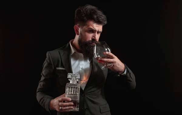 El hombre a la moda en la camisa blanca y los tirantes. Hombre bebiendo alcohol de vidrio. Bebida alcohólica. Beber whisky o brandy o coñac . — Foto de Stock