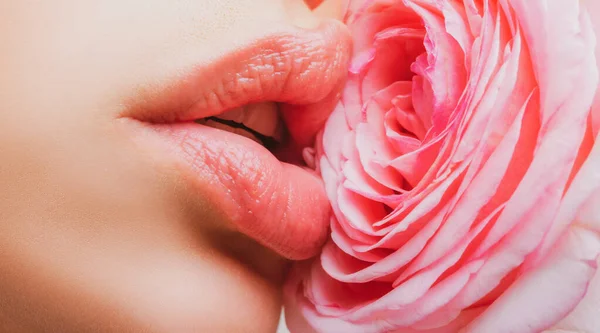 Schöne Nahaufnahme des Gesichts mit leuchtend rosa Lippen und einer rosa Rose an der Wange. Schöne Frauenlippen mit Rose. — Stockfoto