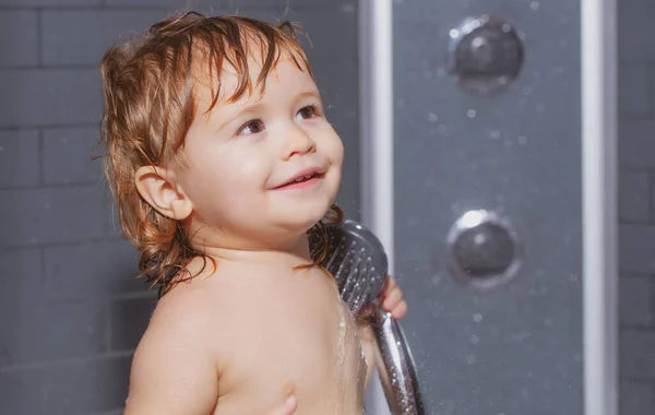 可爱的孩子在浴缸里玩耍。婴儿用泡沫和肥皂泡在浴室里洗澡.有趣的孩子面对特写. — 图库照片