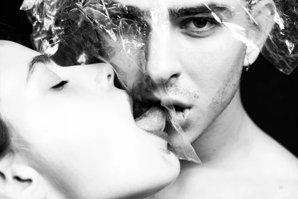 Oral condom concept. Protecting health. Health protection. Sexually transmitted diseases. Sexual activity. Sex health. Couple kissing through transparent plastic. Girl sexy tongue lick guy. Safe sex — Stock Photo, Image