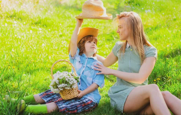 ピクニックで息子と幸せな母の日。公園で草の上に座っている子供を持つ家族のお母さん. — ストック写真