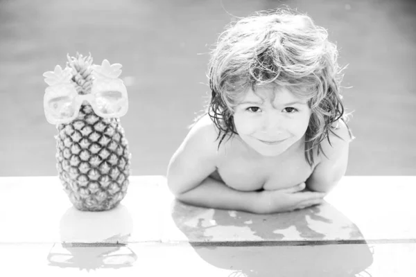 Felice ragazzo elegante gode la vita sulla piscina estiva. Frutta dell'ananas estiva. — Foto Stock