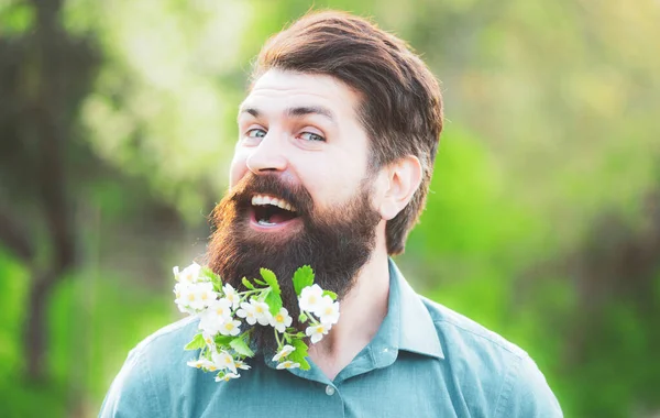 Barbe fleurie. Homme barbu avec des fleurs de printemps dans la barbe . — Photo