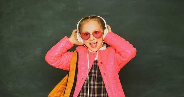 Jugendliche Schülerin mit Brillenrucksack und Kopfhörer. — Stockfoto