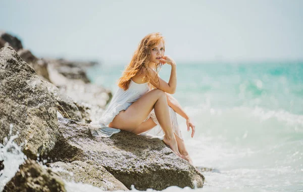 Junge sinnliche Frau sitzt am Strand. Frau entspannt am Wasser auf See sitzen, Urlaub und Wochenendurlaub im Sommer genießen. — Stockfoto
