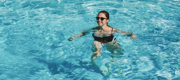 Sommarpoolanläggning. Glad kvinna i poolen. Sommarhelgen. Sommarsemester. Poolfest. — Stockfoto