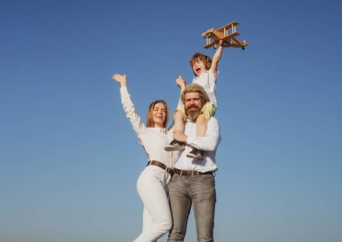Aile günü dışarıda. Çocuklar bayılır. Babasının omuzlarında oyuncak uçağı olan bir çocuk. Annelik babalığı. Oğlu baba annesi. Çocuklu genç ebeveynler.