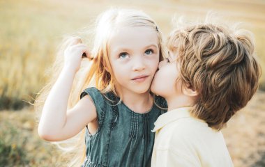 Çocuklar mavi gökyüzü arka planına karşı yeşil alanda eğleniyorlar. Kutlama Sanat Kutlama Kartı. Güzel çocuklar. Aşık küçük melekler. Aşk konsepti. - Valentine. Aşk hikayesi..