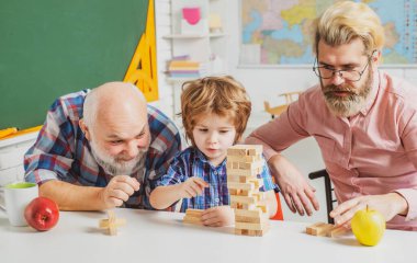 Evde Jenga oyunu. Mutlu jenerasyon dilsizler üç nesil erkek aile portresi. Farklı çağlardaki insanlar..