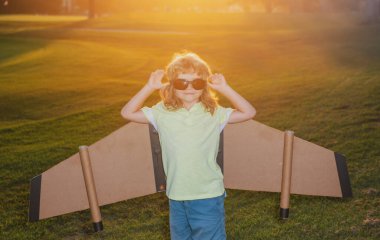 Karton kanatlı çocuk hayal gücü pilot olmayı hayal eder. Yaratıcı ve yenilikçi kavram. Başarı çocuklar ve lider konsepti.