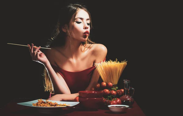 Una mujer sensual come espaguetis. Concepto de comida saludable. Hambre y apetito. Chica sorprendida con fideos de espagueti. Macarrones largos de pasta. — Foto de Stock