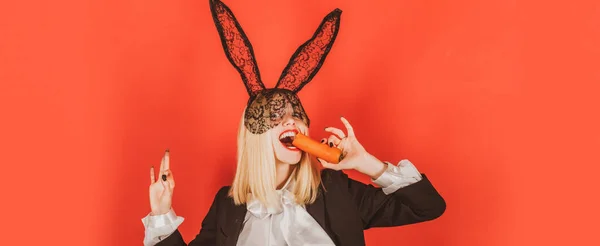 Osterbanner mit Hasenfrau. Osterfest. Sinnliche Frau mit schwarzen Hasenohren aus Spitze mit Karotte. Sexy Osterhase isst Karotte. — Stockfoto