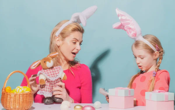 Щасливого Великодня. Мати і дочка починають полювати на великодні яйця. Щаслива сім'я готується до Великодня. Симпатична маленька дівчинка у вухах кролика на Великдень . — стокове фото