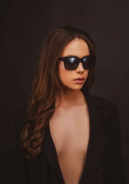 Moda sanatları stüdyosunda siyah gözlüklü zarif genç bir kadının portresi..
