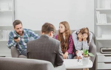 Aile psikoloji seansında. Psikolog, baba, anne ve kız için aile terapisi uyguladı..