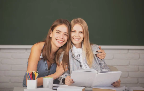 Krásné studentky dívky objímání a objímání ve třídě na vysoké škole. — Stock fotografie