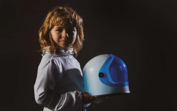黒の背景にヘルメットを保持宇宙服のかわいい男の子宇宙飛行士の子供。宇宙を想像する子供たち. — ストック写真