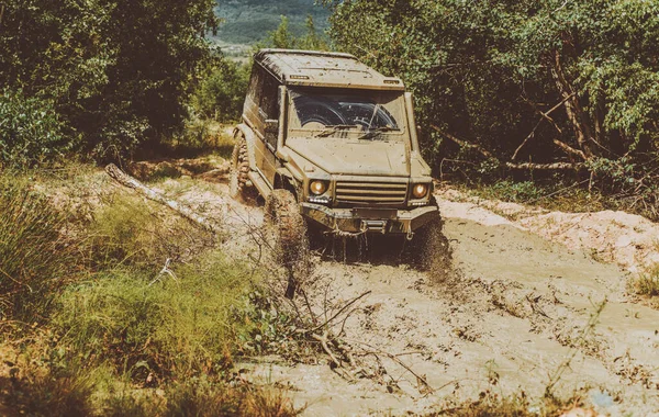 Off-road travel on mountain road. Drag racing car burns rubber. Extreme. Off-road car. Offroad vehicle coming out of a mud hole hazard. Road adventure. Adventure travel. — Stock Photo, Image