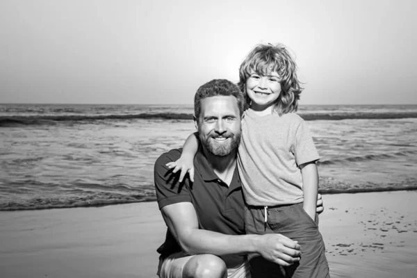 Baba oğul kumsalda gün batımında sarılıyorlar. Küçük oğlum, gün doğumunda babanı kucakla.. — Stok fotoğraf