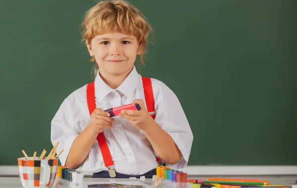 Barnpojken i skolan tecknar med färger. Konstnärlig kreativitet för barn. Lärande i barndom, konstnärliga färdigheter för barn. — Stockfoto