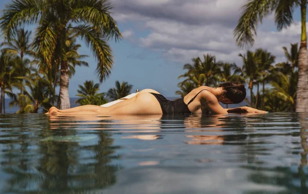 Mulher elegante Sexy na piscina infinito e goza da vista sobre o mar azul. — Fotografia de Stock