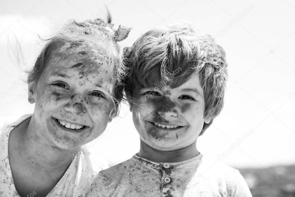 Smiling little kids portrait. Painted faces of funny kids. Children holi festival of colors. Little boy and girl plays with colors.