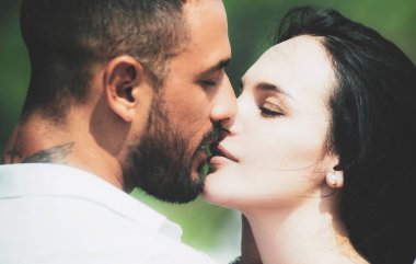 Aşık bir çiftin romantik portresi. Nazik romantik çift tüm sevgililerin gününü kutlar. Güzel genç bir çift yüz yüze otururken gülümsüyor..