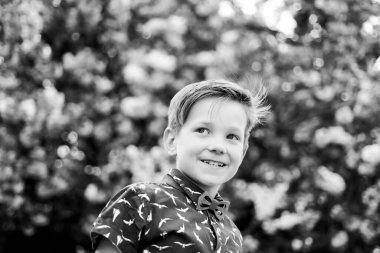 Gülümseyen mutlu çocuk pembe çiçekli Japon sakura arka planında. Bahar çiçekleri açar..