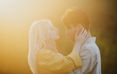 Şehvetli aşıklar gün batımında sarılıp öpüşüyorlar. Birbirine aşık, şehvetli aşıklar kucaklaşıp sarılıyorlar..