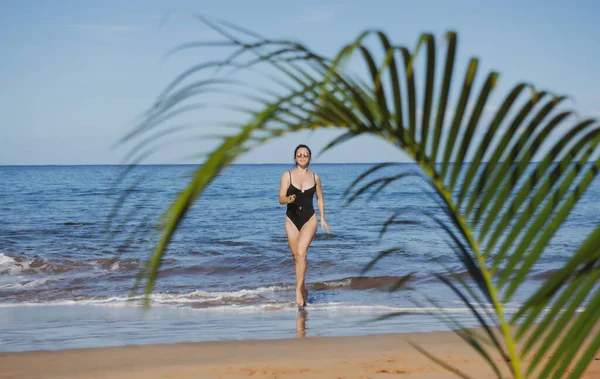 Mujer joven corriendo en una playa. Playa paradisíaca tropical con arena blanca y palmeras, Concepto de turismo de viajes. —  Fotos de Stock