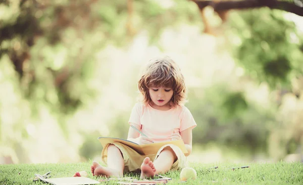 Educación para niños al aire libre. Niño de escuela primaria que estudia en el parque. —  Fotos de Stock