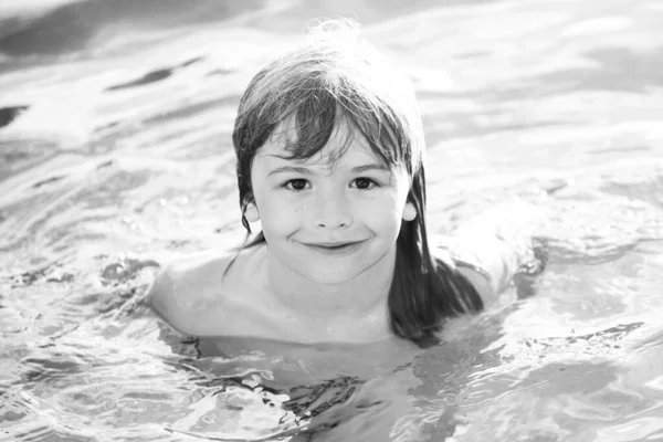 Porträt eines kleinen Jungen, der im Meer schwimmt. Kind lacht im Wasser der Wellen auf dem Meer. Lustige Kindergesichter. — Stockfoto