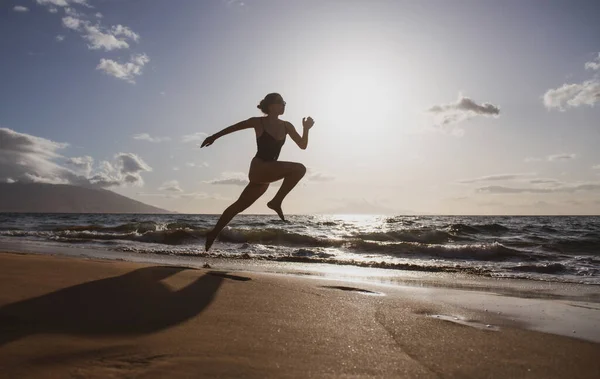 ビーチジョギングでスプリントワークアウトを実行しているランナーの女性のシルエット,健康的な屋外活動. — ストック写真