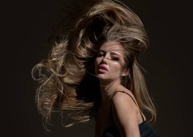 Parlak saçlı güzel bir kadın. Genç kızın güzel yüzü, hareket eden saçları. Stüdyoda poz veren seksi kadın model. Vogue tarzı portre yakın plan.