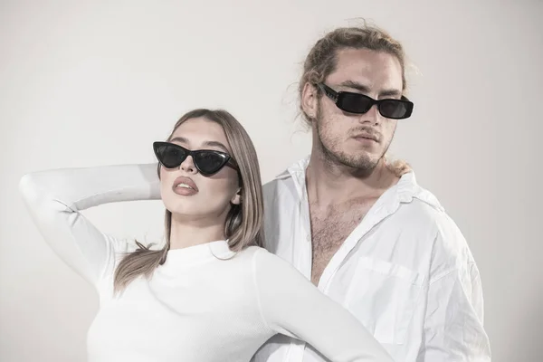 Пара в моде черных солнцезащитных очков. Молодая пара позирует в солнечных очках. Студия на сером фоне. — стоковое фото