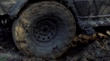 Hasarlı yolda off-car tekerlekleri. Lastikler kötü yolda. Açık hava, maceralar, keşif gezisi ve seyahat cipi. Arabanın tekerlek izlerini kapatın. Kötü bir yoldaki kamyon. Yavaş çekim.