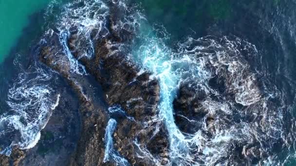 Olas y rocas. Textura de olas marinas. Vista de fondo de la naturaleza desde el dron. Agua azul del océano con rocas entre espuma en la playa Laguna, California. — Vídeo de stock