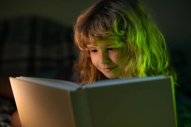 Çocuk kitap okuyor. Çocuklar yatma vakti, çocuk yatakta kitap okuyor. Uyku masalı, çocuk masalı..