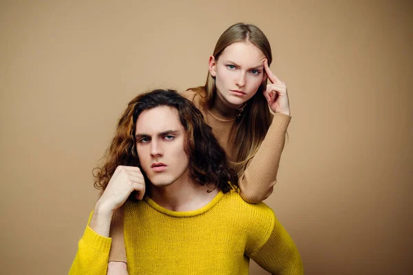 Concepto de peluquería o peluquería. Retrato de pareja joven. Pareja de moda sobre fondo beige en estudio. Coupl de moda. Pareja de hombre con pelo rizado y mujer rubia en peluquería. —  Fotos de Stock