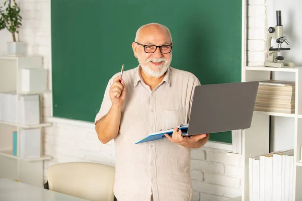 老年教育和退休知识概念。在大学或学院的课堂上任教.带着电脑笔记本电脑的老男生上船了。课堂技巧。成熟的男人在高中学习 — 图库照片